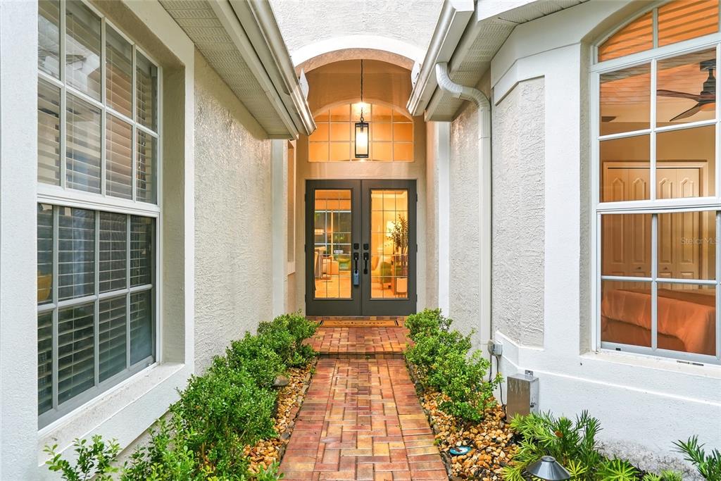 A single-story suburban house with a tan stucco exterior, a two-car garage, and landscaped lawn — 10413 APPLECROSS LANE, TAMPA, FL