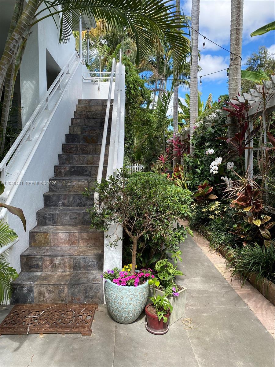 An outdoor stone staircase leads to an upper level beside a lush garden path — 525 NE 63rd St # 4, Miami FL 33138, MIAMI, FL