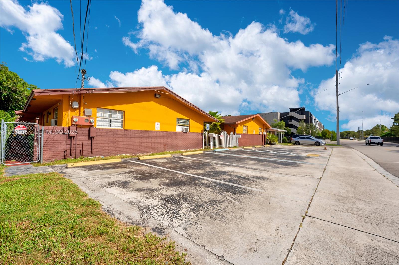 A yellow and brown single-story building with a paved parking lot in front — 129-131 SE 5th St, Hallandale Beach FL 33009, HALLANDALE BEACH, FL