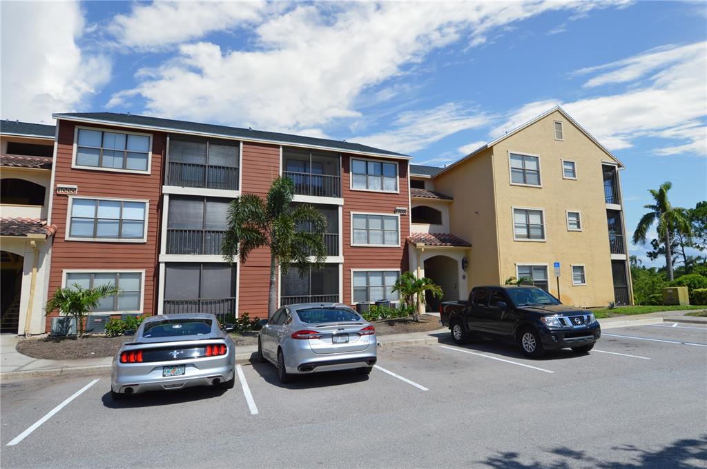 A three-story apartment building with a parking lot and three parked cars in front — 11901 4TH STREET N UNIT 10105, ST PETERSBURG, FL