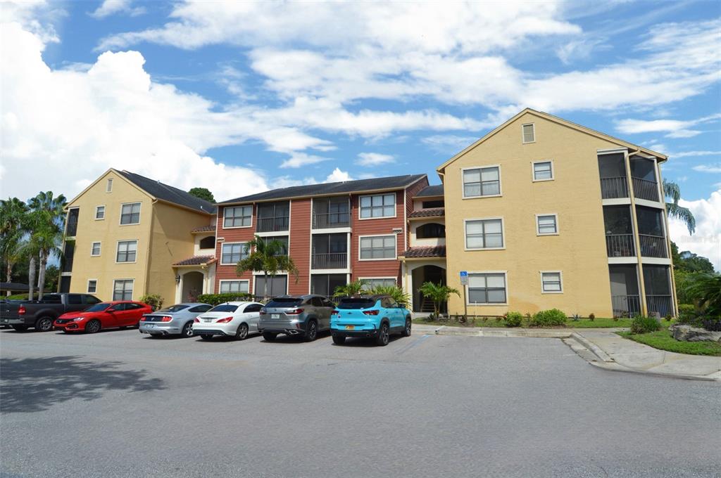 A multi-story apartment building with a parking lot in front under a blue sky — 11901 4TH STREET N UNIT 10105, ST PETERSBURG, FL