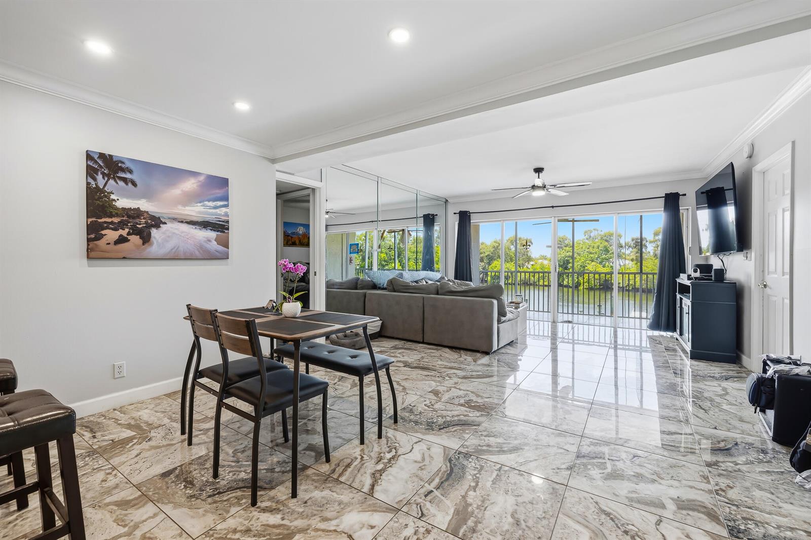 A dining and living area features marble-look tile floors, mirrored walls, and a balcony view — 1319 E Hillsboro Boulevard # 208, Deerfield Beach FL 33441, DEERFIELD BEACH, FL