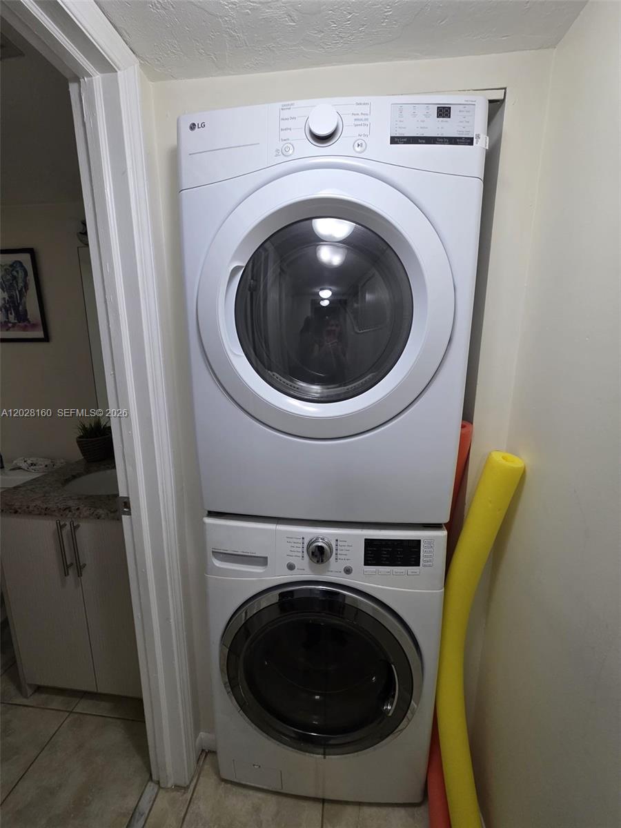 A stacked LG washer and dryer unit sits in a small laundry closet — 450 Commodore Dr # 108, Plantation FL 33325, PLANTATION, FL
