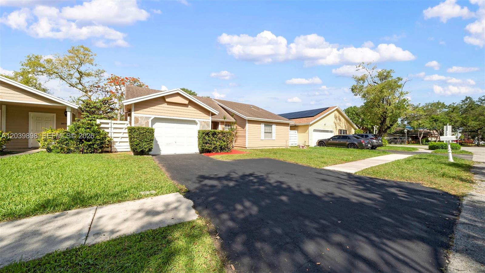 A tan single-story house with a garage and driveway sits on a grassy lot — 14780 SW 139th Ct, Miami FL 33186, MIAMI, FL