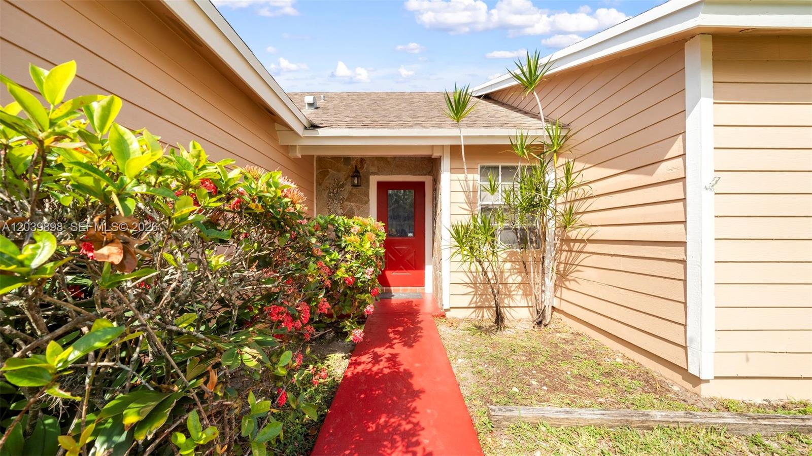 The exterior of a house features a red front door and a matching red walkway — 14780 SW 139th Ct, Miami FL 33186, MIAMI, FL