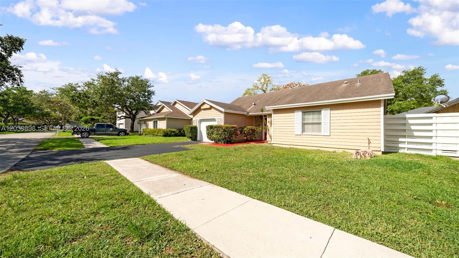 A single-story house with tan siding, a brown roof, and a paved driveway — 14780 SW 139th Ct, Miami FL 33186, MIAMI, FL