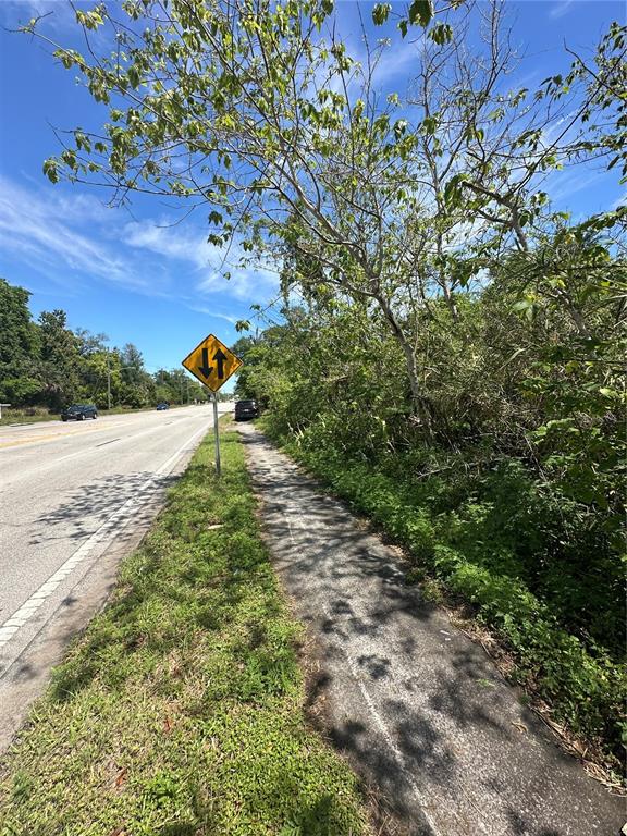 A paved sidewalk runs alongside a road with a two-way traffic sign and trees — 2907 SANFORD AVENUE, SANFORD, FL