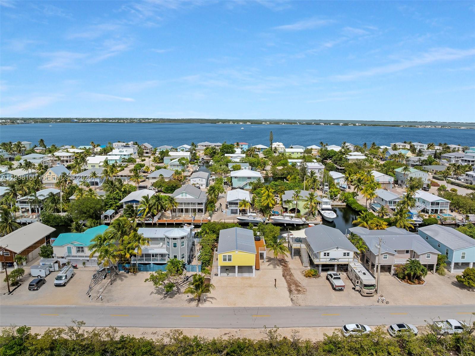 An aerial view shows a coastal neighborhood with houses, canals, and boats along the water — 437 Pirates Rd, Torch Key FL 33042, TORCH KEY, FL