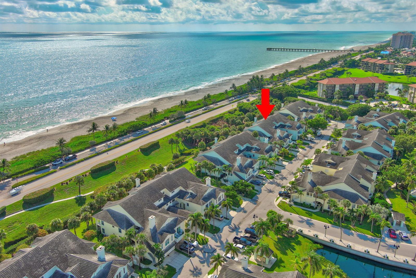 An aerial view of a coastal residential complex with a red arrow pointing to a unit — 205 Mainsail Circle, Jupiter FL 33477, JUPITER, FL