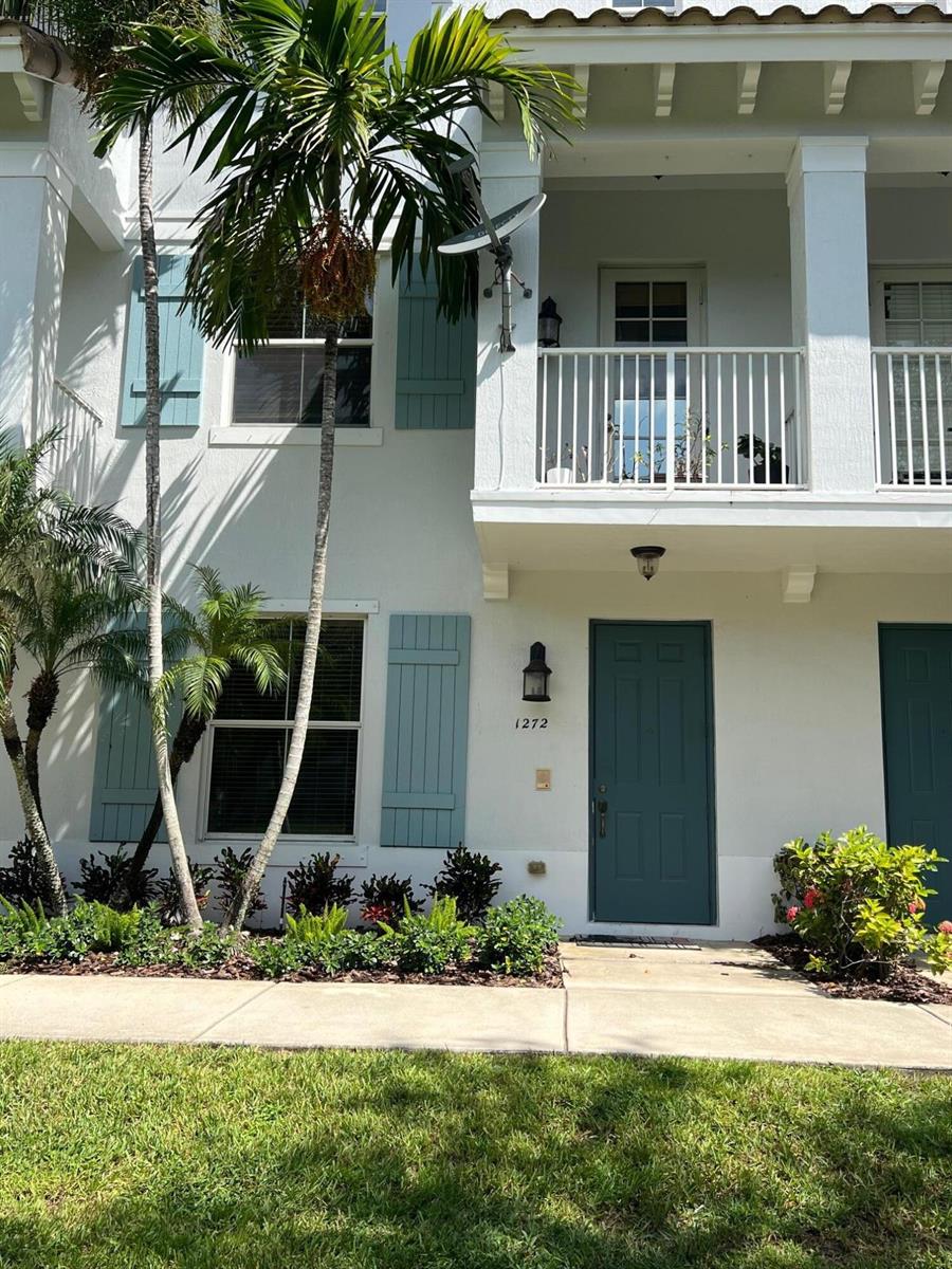 A two-story white townhouse features a teal front door, matching shutters, and a balcony — 1272 Via Fiume, Boynton Beach FL 33426, BOYNTON BEACH, FL