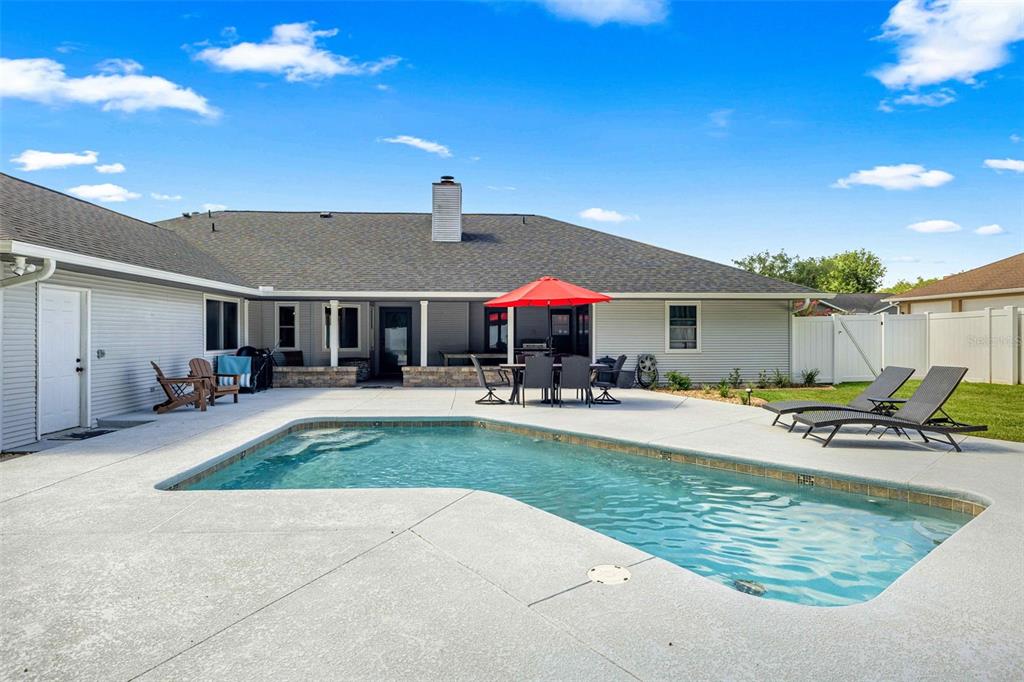 A brick house exterior features a front door, two windows, and an American flag — 2611 SE 27 STREET, OCALA, FL