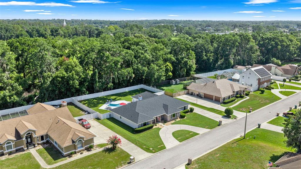 A backyard features a swimming pool, a patio with dining furniture, and a house exterior — 2611 SE 27 STREET, OCALA, FL