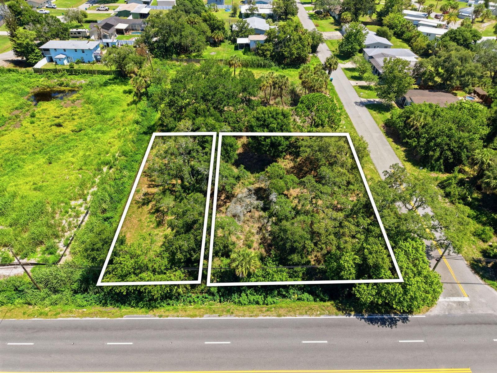 An aerial view shows two adjacent, wooded rectangular lots bordering a paved road — 0 Aurora Road, Melbourne FL 32935, MELBOURNE, FL
