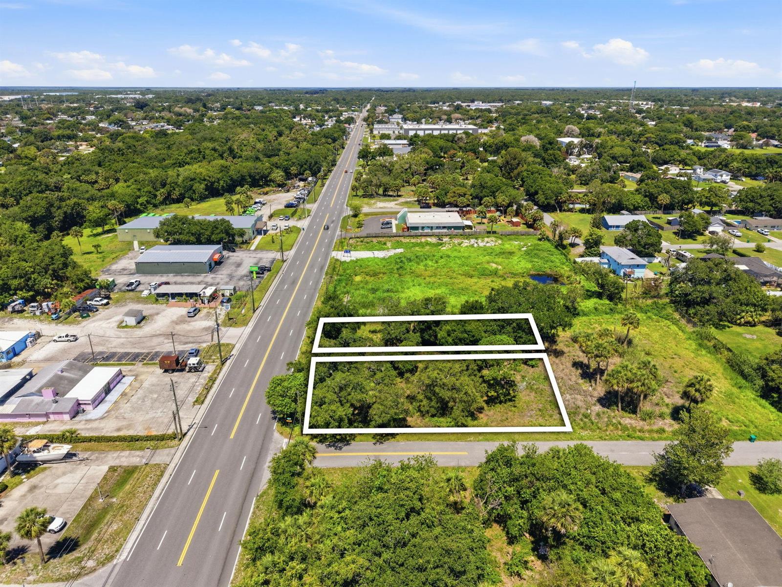 An aerial view shows two rectangular vacant lots outlined in white next to a road — 0 Aurora Road, Melbourne FL 32935, MELBOURNE, FL