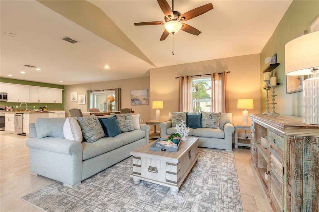 A living room with light blue sofas, a wooden coffee table, and an open kitchen — 119 OCEANS CIRCLE, DAYTONA BEACH SHORES, FL