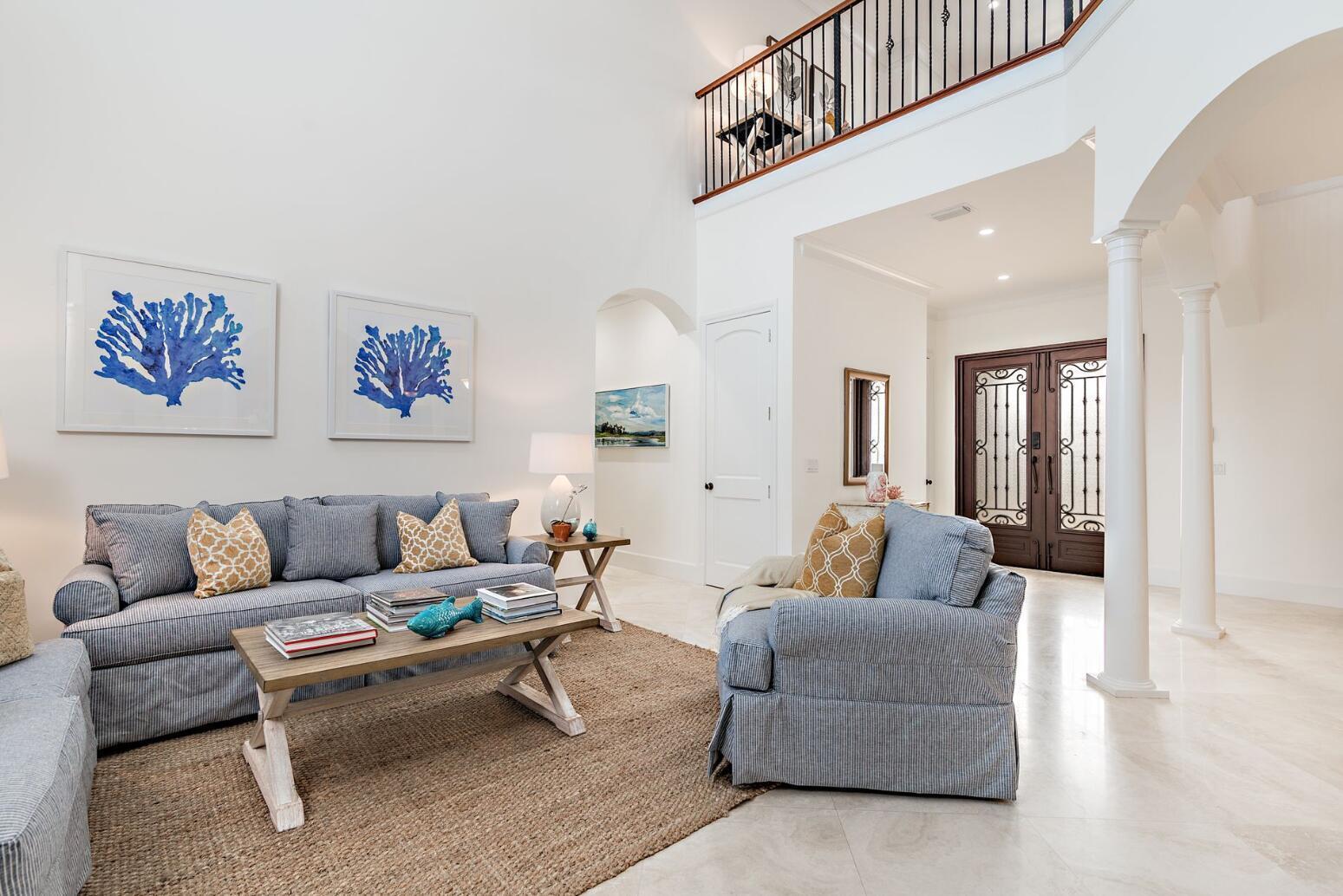 A living room with a striped sofa, armchair, coffee table, and a high ceiling — 141 Gregory Place, West Palm Beach FL 33405, WEST PALM BEACH, FL