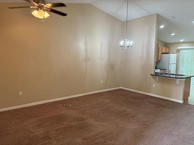 An open living area features tan walls, brown carpeting, a ceiling fan, and a chandelier — 113 BRUNSWICK LANE UNIT B, PALM COAST, FL