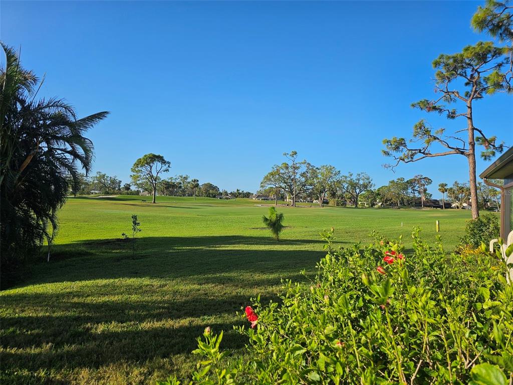 A view of a grassy golf course with scattered trees under a clear blue sky — 4522 LA JOLLA DRIVE, BRADENTON, FL