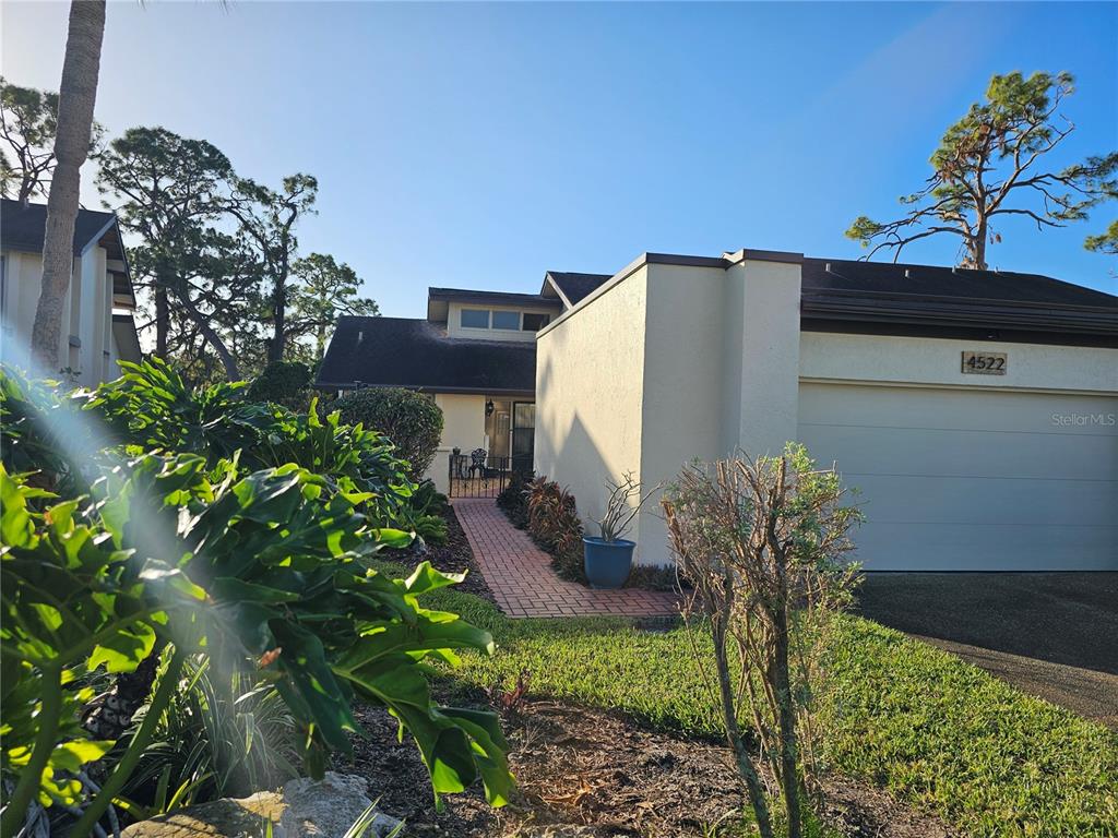 A single-story house with a beige exterior, a brick walkway, and an attached garage — 4522 LA JOLLA DRIVE, BRADENTON, FL