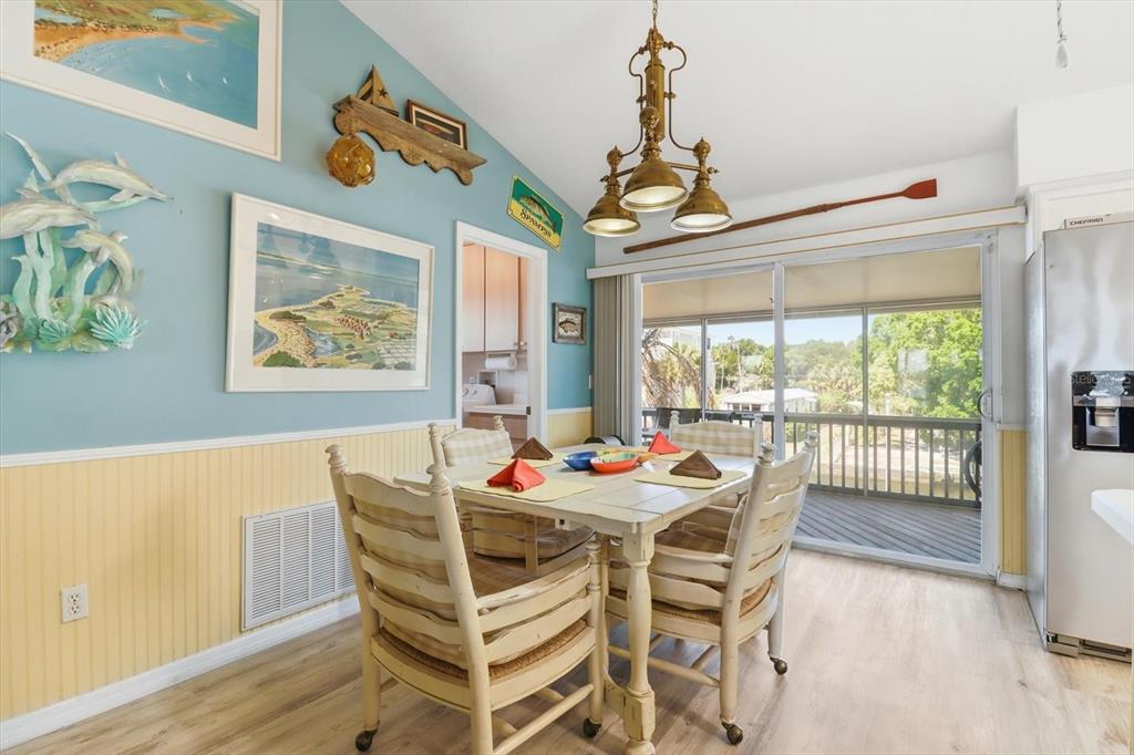 A dining room features a wooden table, four chairs, light blue walls, and a sliding door — 2882 N COMANCHE POINT, CRYSTAL RIVER, FL