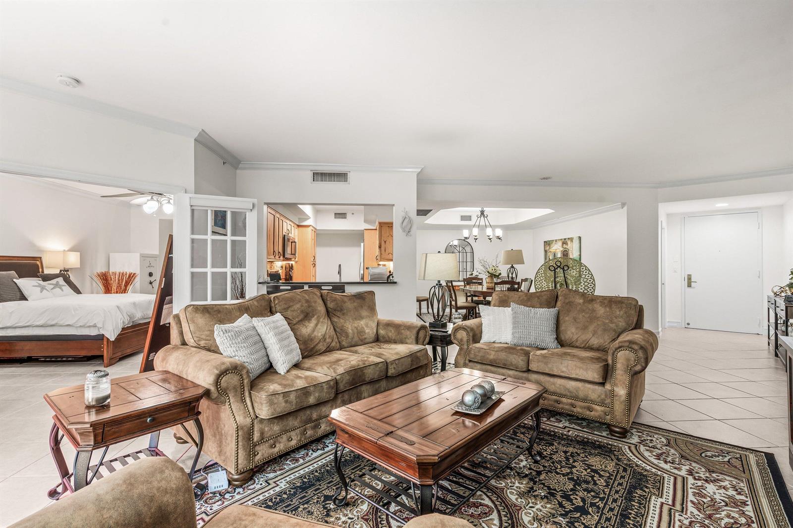 A living room with two brown sofas, a wooden coffee table, and an adjacent bedroom — 500 SE Mizner Boulevard # A209, Boca Raton FL 33432, BOCA RATON, FL