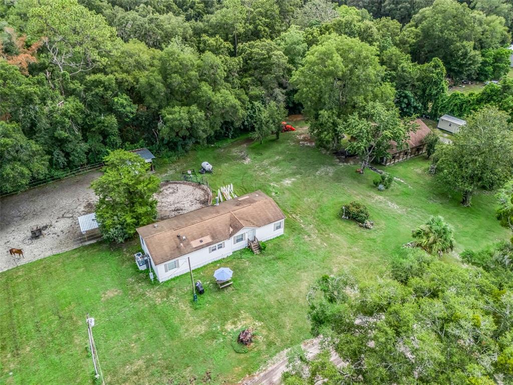 An aerial view shows a single-story house with a brown roof on a wooded lot — 4603 NW 61ST LANE, OCALA, FL