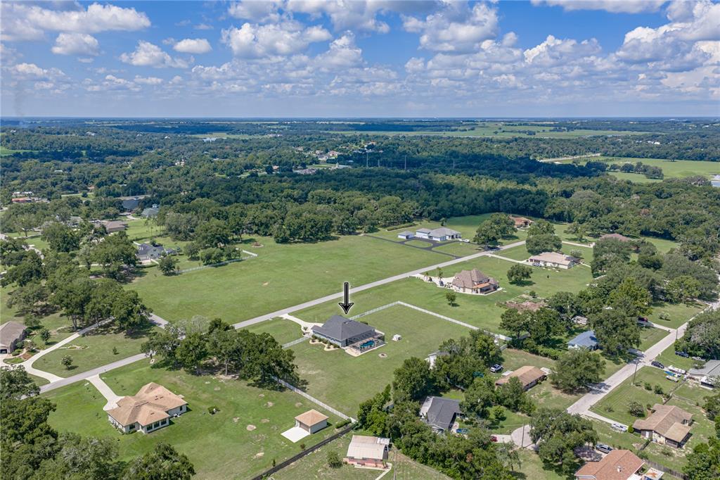An aerial view shows a residential house with a pool on a large, grassy lot — 37405 HIGHRIDGE DRIVE, DADE CITY, FL