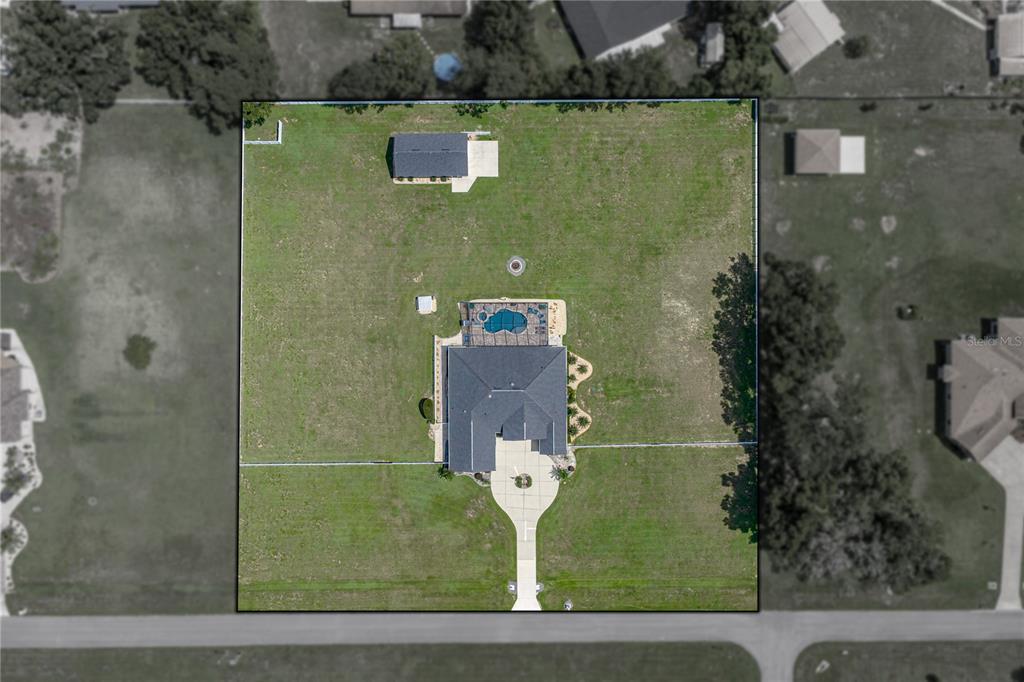This aerial view shows a house with a pool and a detached garage on a lot — 37405 HIGHRIDGE DRIVE, DADE CITY, FL