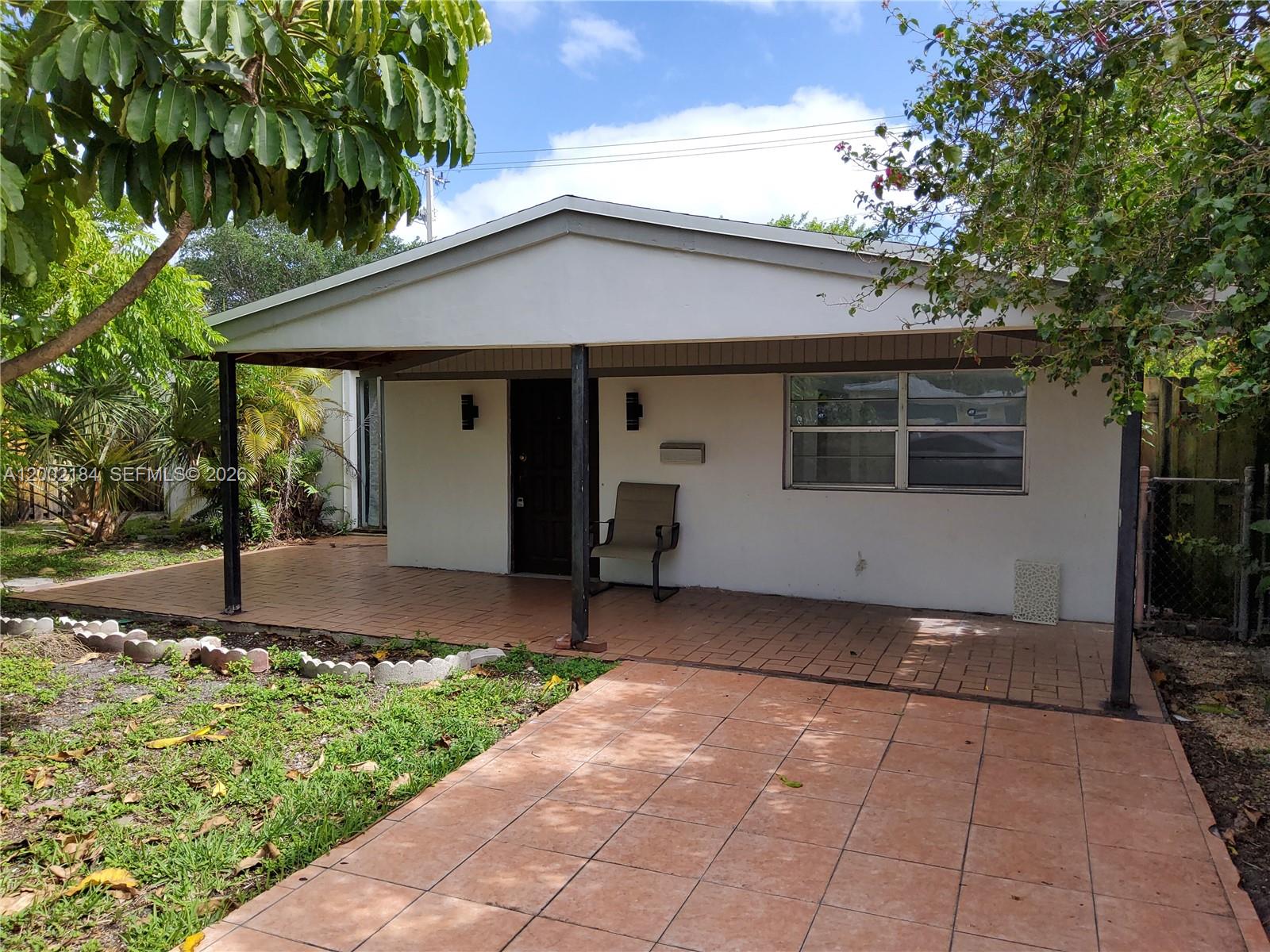 A single-story house features a covered front patio, tiled flooring, and a small front yard — 1348 NE 176th St, North Miami Beach FL 33162, NORTH MIAMI BEACH, FL