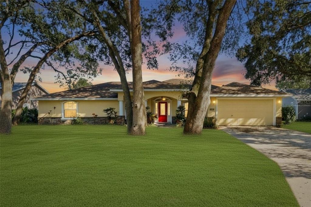 A single-story house with a yellow exterior, red front door, and a two-car garage — 2120 WILDWOOD LANE, AUBURNDALE, FL