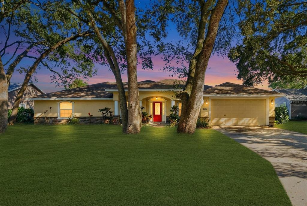 A single-story house with a yellow exterior, red front door, and a two-car garage — 2120 WILDWOOD LANE, AUBURNDALE, FL
