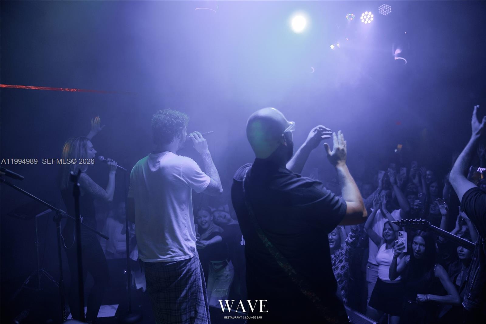 A live band performs on a stage before a crowd in a dimly lit club — 115 S 20th Ave, Hollywood FL 33020, HOLLYWOOD, FL