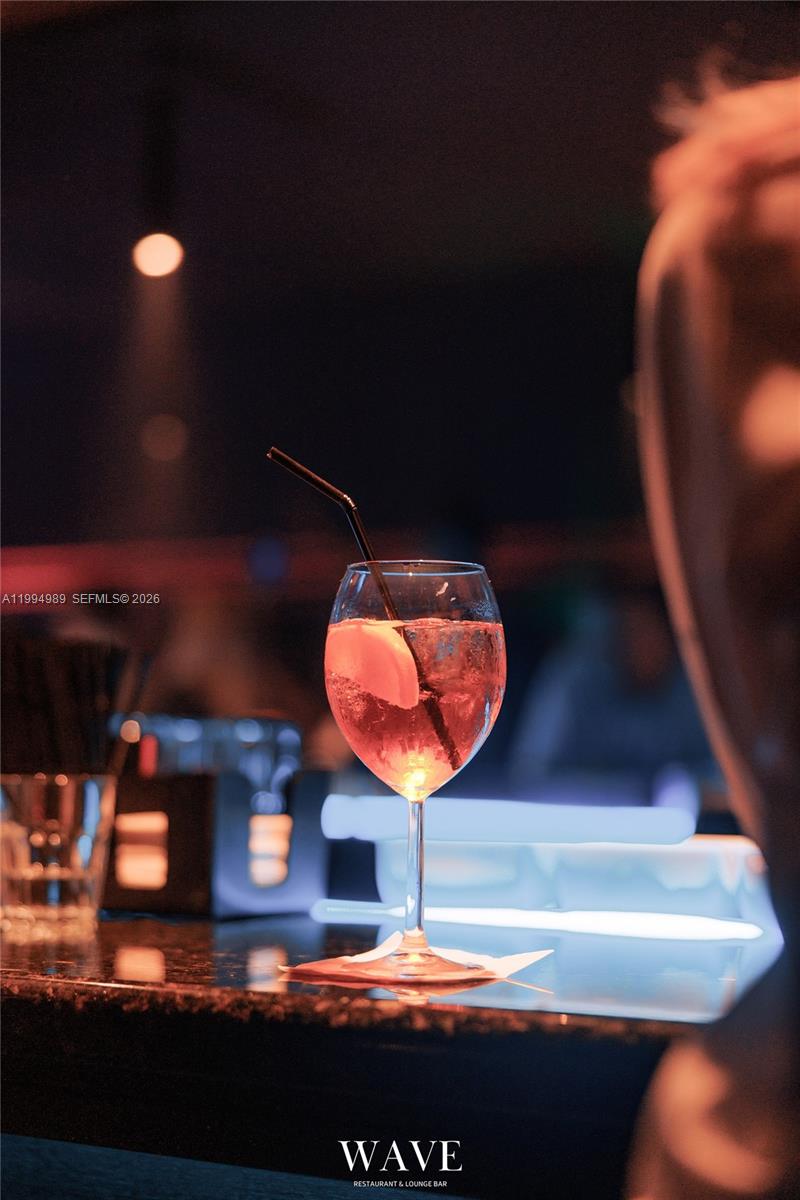 A cocktail in a glass sits on a bar counter in a dimly lit lounge — 115 S 20th Ave, Hollywood FL 33020, HOLLYWOOD, FL