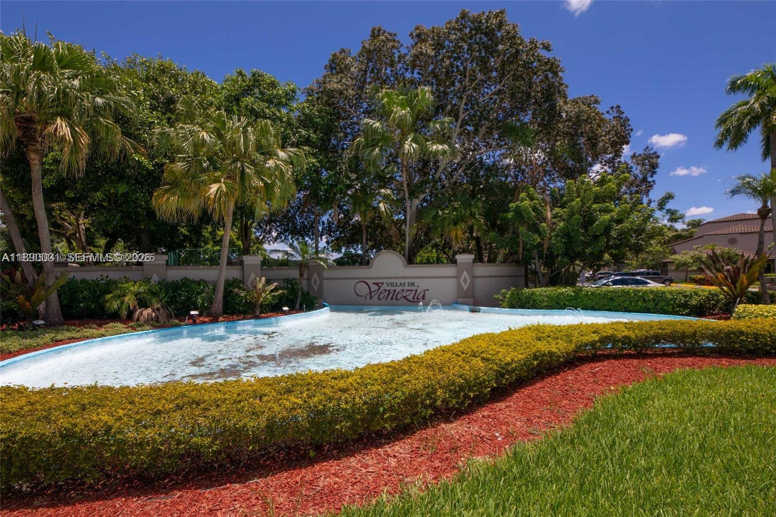 A community entrance sign for Villas de Venezia features a fountain and lush landscaping — 9937 Nob Hill Pl # 1637, Sunrise FL 33351, SUNRISE, FL