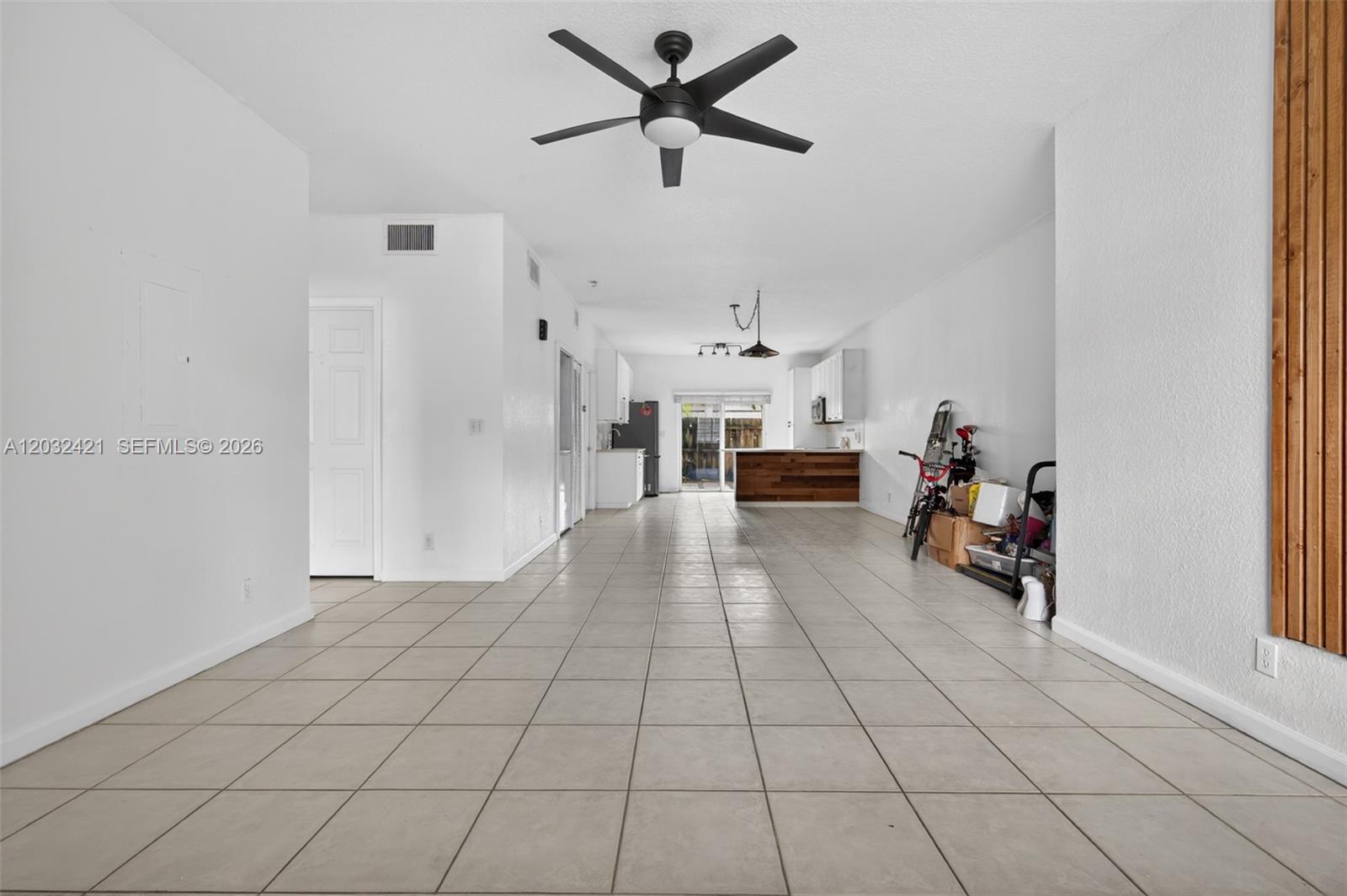An open-concept living area features white walls, tile flooring, a ceiling fan, and a kitchen — 4902 Washington St # 4, Hollywood FL 33021, HOLLYWOOD, FL
