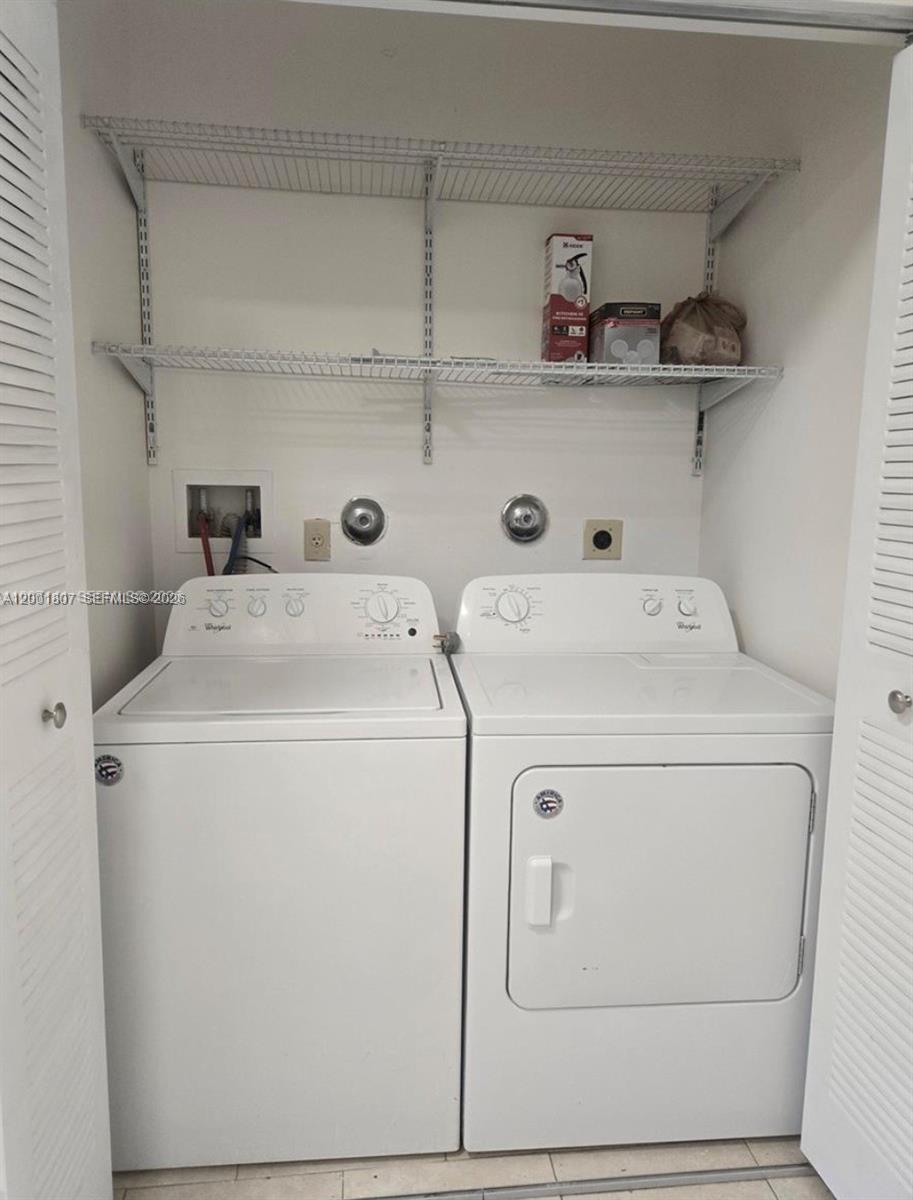 A laundry closet contains a white top-loading washing machine, a dryer, and wire shelving — 9740 NW 5th Ave # B, Miami FL 33150, MIAMI, FL