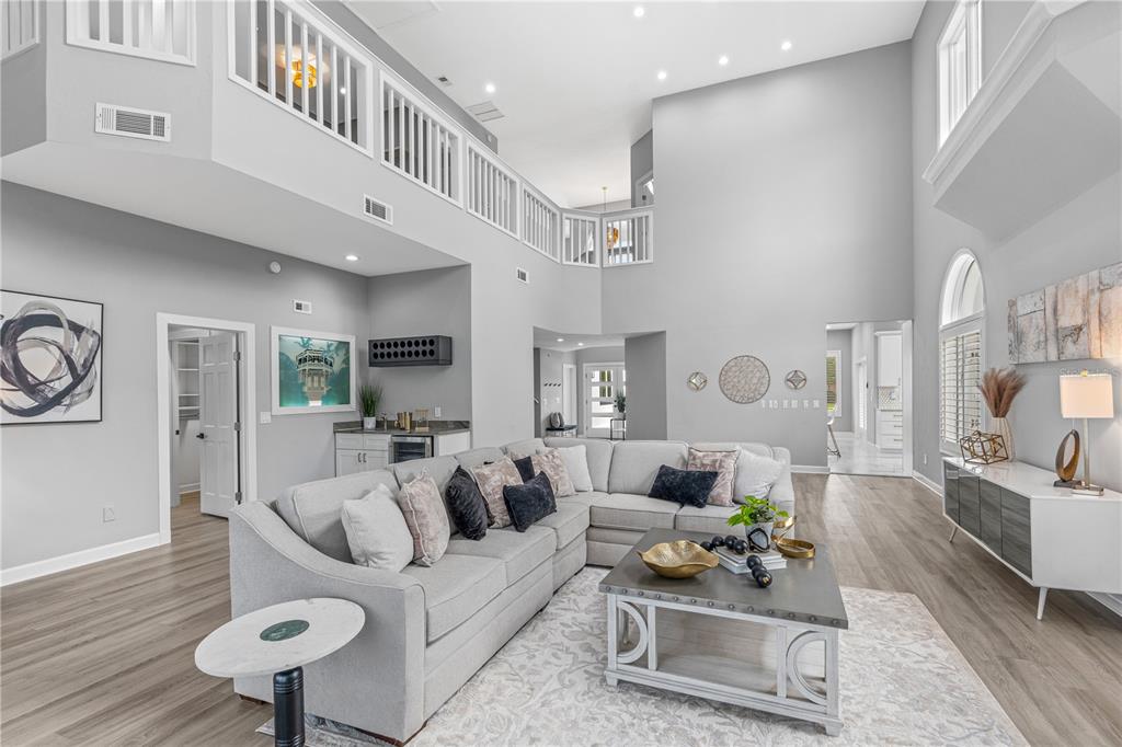 A spacious living room with a sectional sofa, high ceilings, and a lofted balcony — 57 BAY POINTE DRIVE, ORMOND BEACH, FL