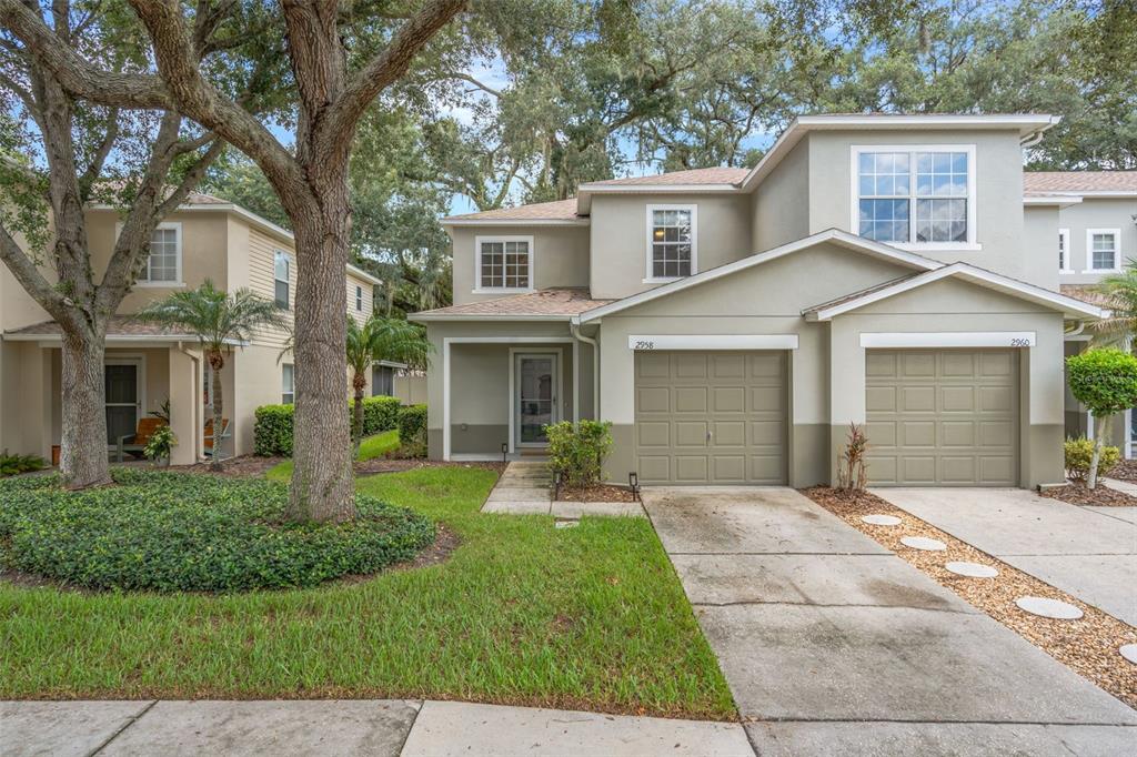 A two-story townhouse with a tan exterior, a single-car garage, and a front lawn — 2958 ROYAL TUSCAN LANE, VALRICO, FL