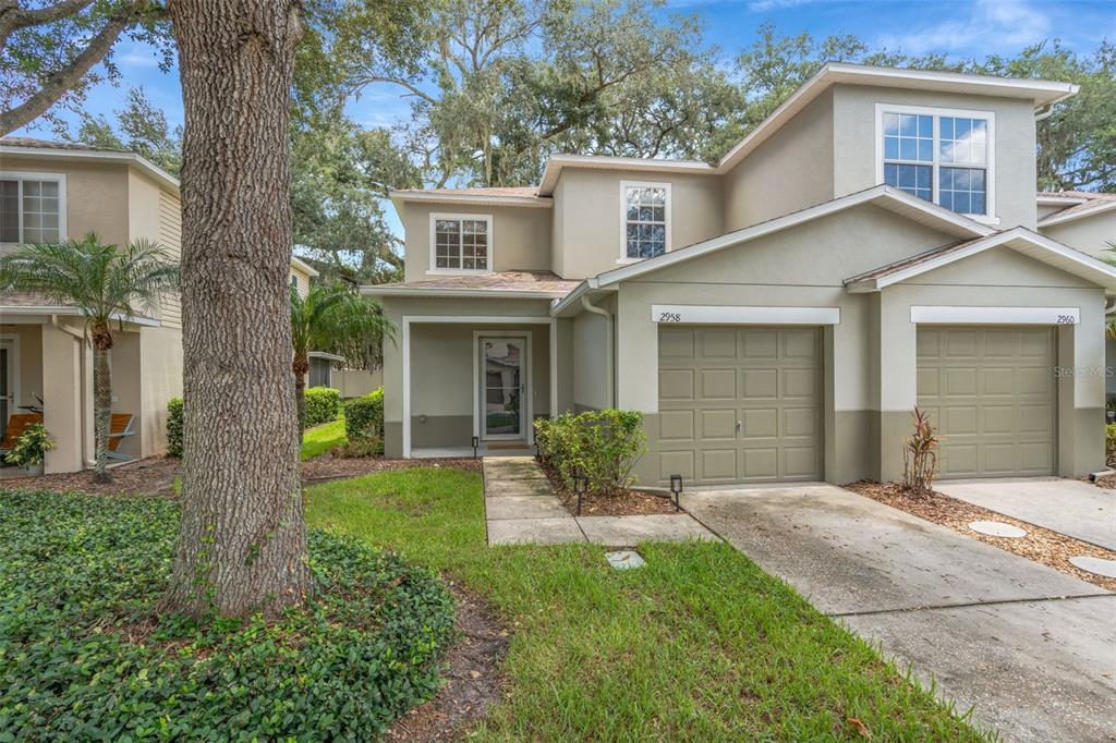 A two-story duplex with tan stucco siding, attached garages, and a front walkway — 2958 ROYAL TUSCAN LANE, VALRICO, FL