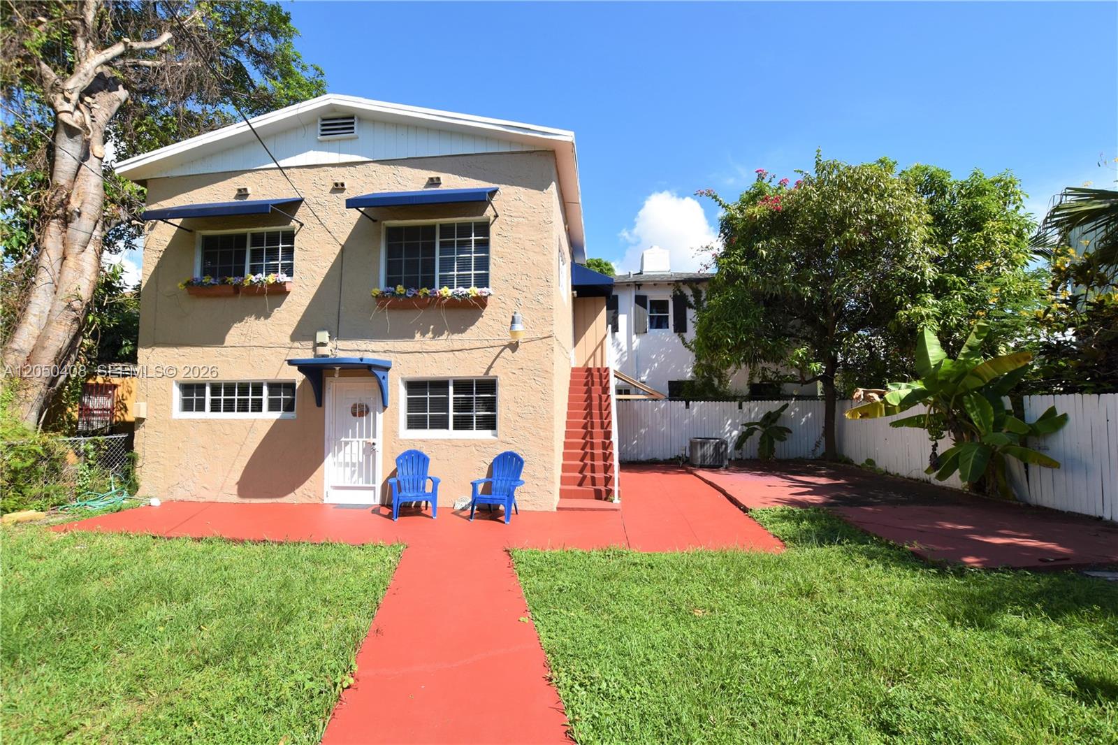A two-story tan house with blue awnings, a red patio, and an outdoor staircase — 2615 SW 20th St, Miami FL 33145, MIAMI, FL