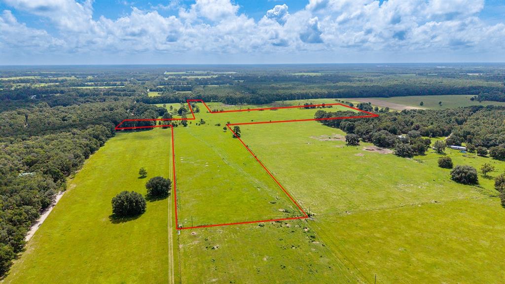 An aerial view shows a large, open grassy field outlined in red — 0000 NW 20TH STREET, BELL, FL