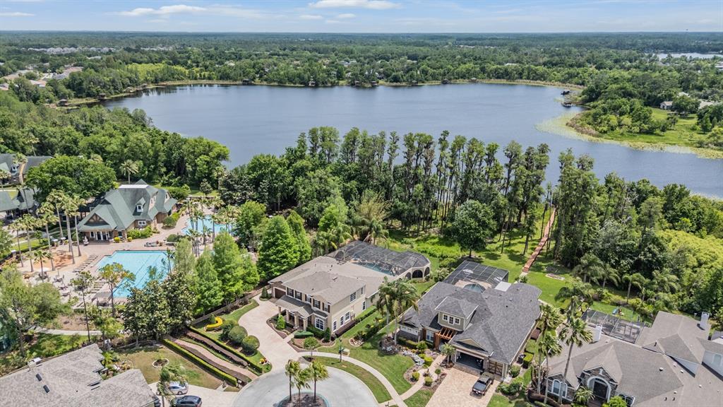 An aerial view shows several large houses with pools near a lake and trees — 21246 QUIET HAVEN COURT, LAND O LAKES, FL