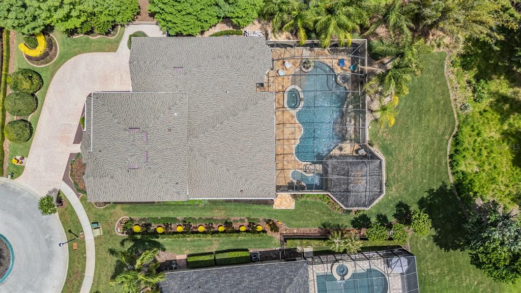 An aerial view shows a house with a screened-in pool, patio, and landscaped yard — 21246 QUIET HAVEN COURT, LAND O LAKES, FL