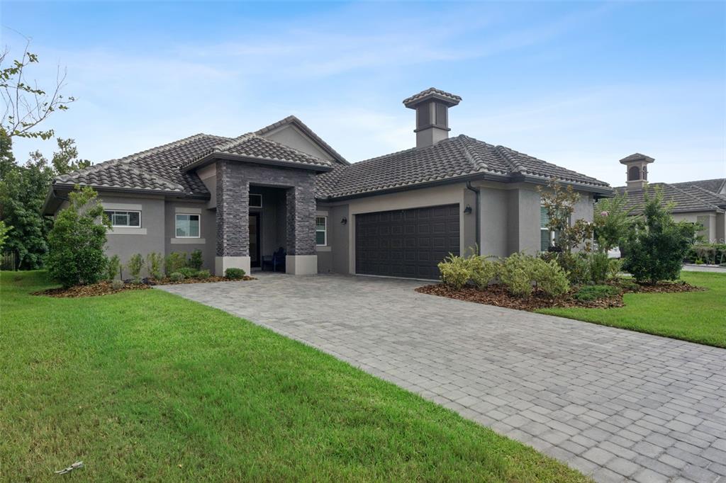 A single-story house with a stone-accented entryway, a two-car garage, and a tiled roof — 2730 WILLINGAM DRIVE, DAVENPORT, FL