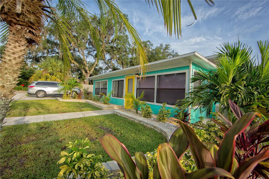 A living room features a red sofa, a wooden dining table, and a daybed — 839 3RD STREET N, SAFETY HARBOR, FL