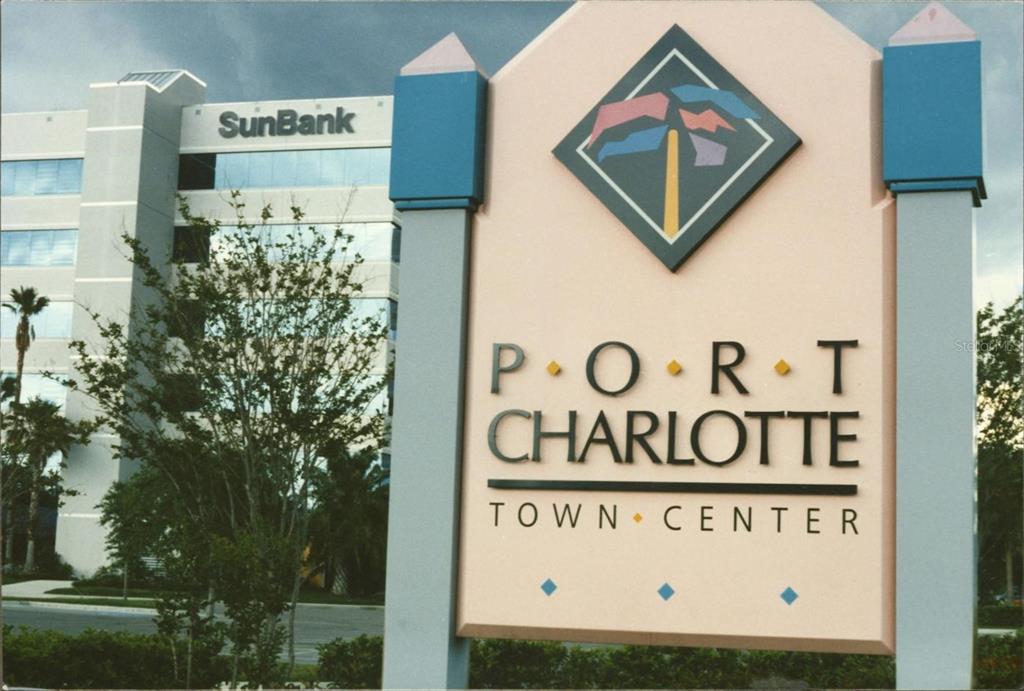 A sign for Port Charlotte Town Center stands in front of a multi-story SunBank building — 1044 BISCAYNE DRIVE, PORT CHARLOTTE, FL