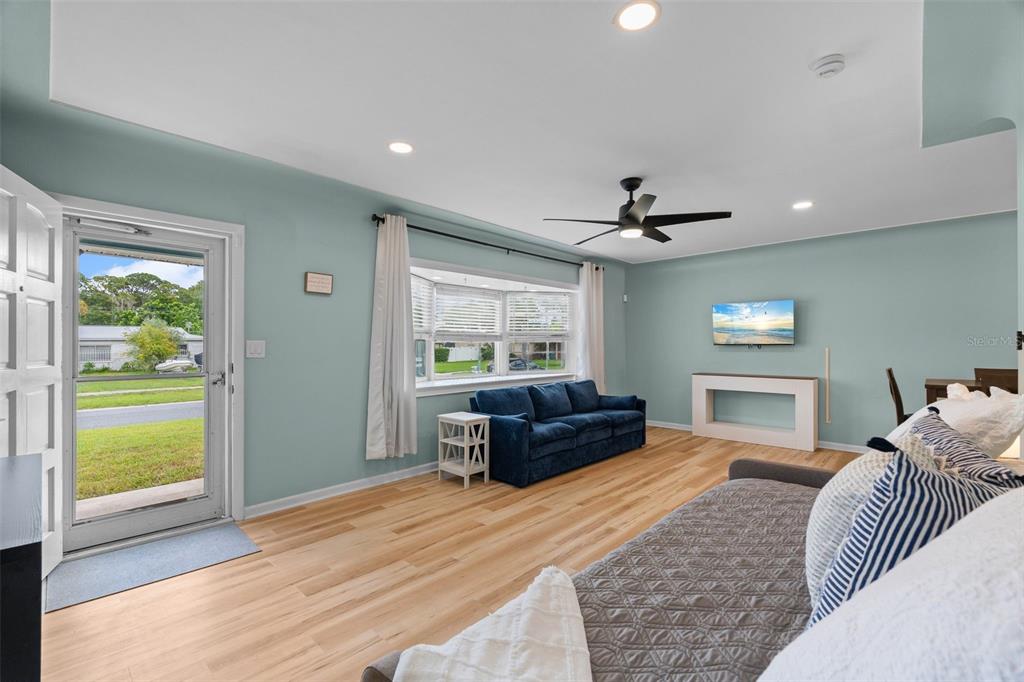 A kitchen features dark blue lower cabinets, white upper cabinets, and a wood countertop — 7690 91ST STREET, SEMINOLE, FL