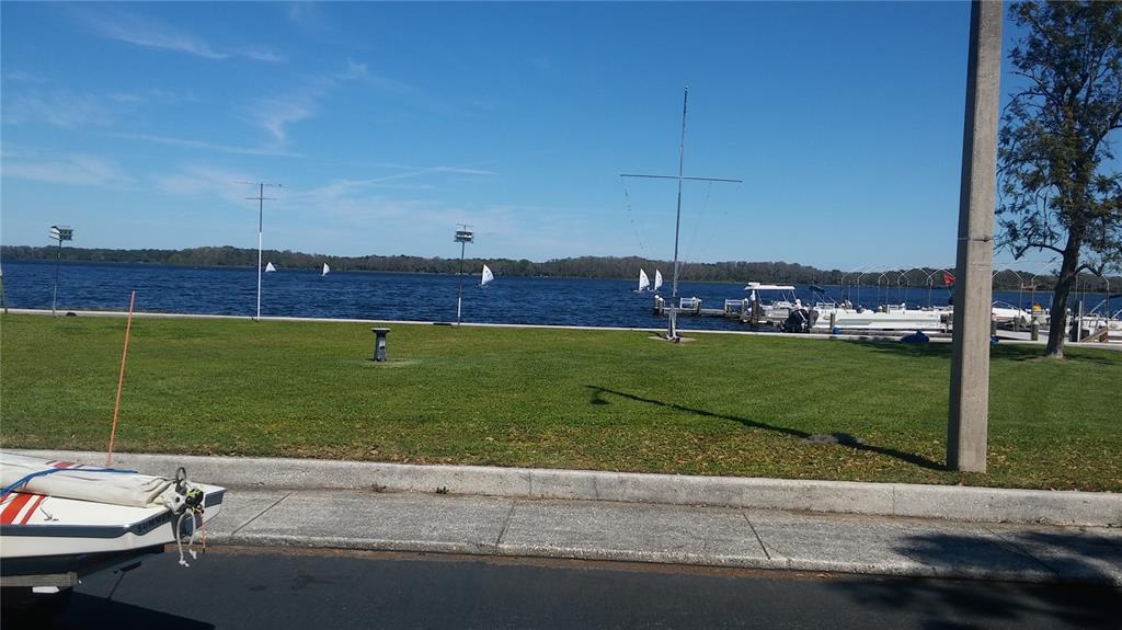 A grassy park area sits along a lake with several sailboats and docks in view — 57 HARBOR WAY UNIT 24, PALM HARBOR, FL