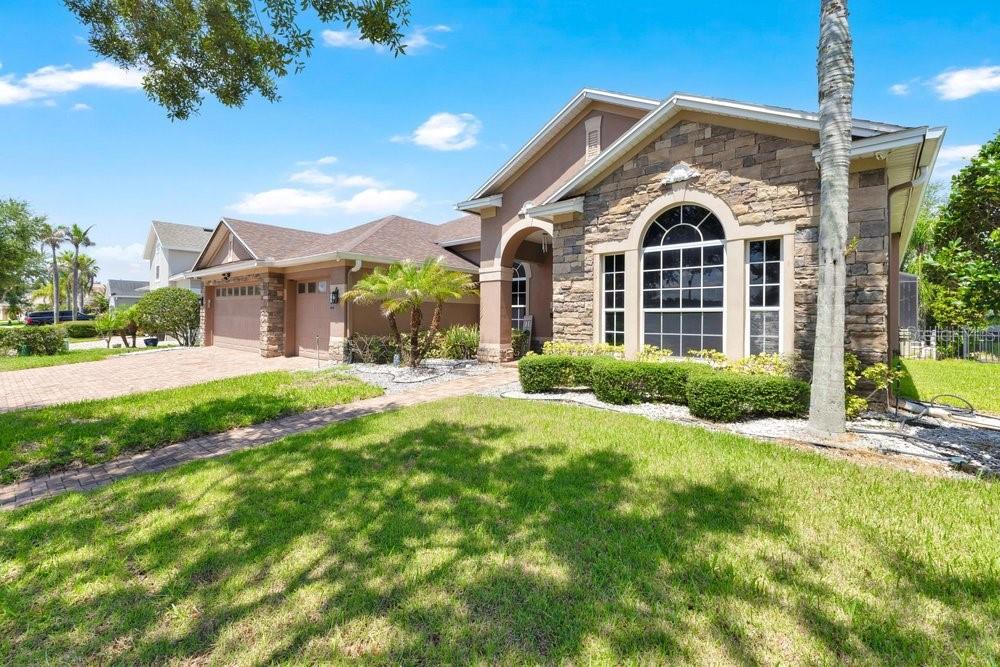 A single-story house with a stone facade, arched window, and a paved driveway — 6658 VISTA PARK BOULEVARD, ORLANDO, FL