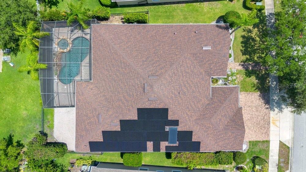 An aerial view shows a house with a pool enclosure and solar panels on the roof — 6658 VISTA PARK BOULEVARD, ORLANDO, FL